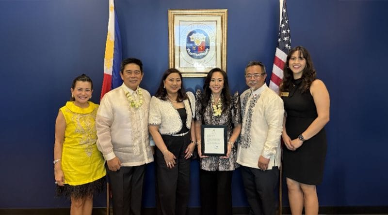 Group photo at the Philippine Honorary Consulate in Chandler, Arizona. Honorary Consul Jenny Lynn Ho-Vijungco stands at the center holding her appointment certificate, joined by dignitaries and guests with Philippine and U.S. flags displayed behind them.